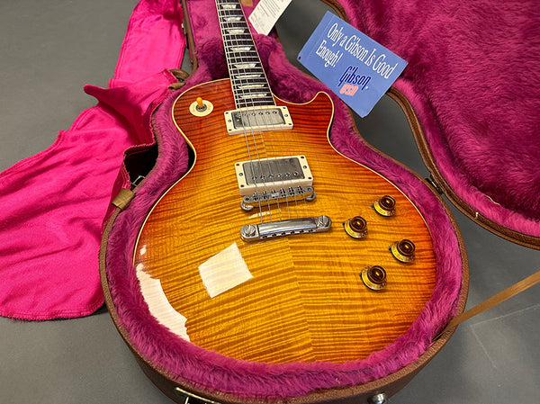 Gibson Les Paul electric guitar with sunburst finish in open hard case with plush pink interior and Gibson branded booklet