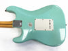 Back of vintage light blue electric guitar body with white plastic tremolo cover and maple neck with skunk stripe and metal neck plate on white background