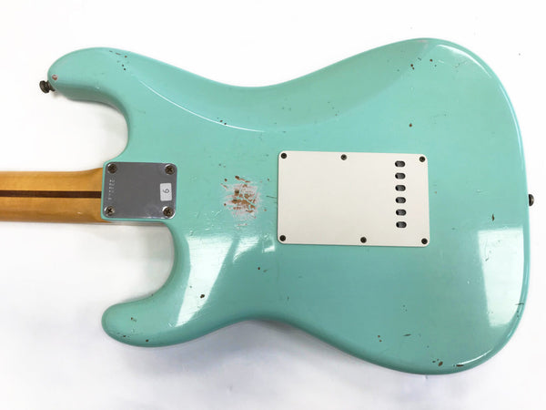 Back of vintage light blue electric guitar body with white plastic tremolo cover and maple neck with skunk stripe and metal neck plate on white background