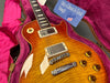 Close-up of sunburst Gibson Les Paul electric guitar with humbucker pickups in pink plush-lined hard case and Gibson USA tag