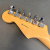 Close-up of Fender guitar maple neck headstock with six chrome tuning pegs and serial number Z8099804 on gray background