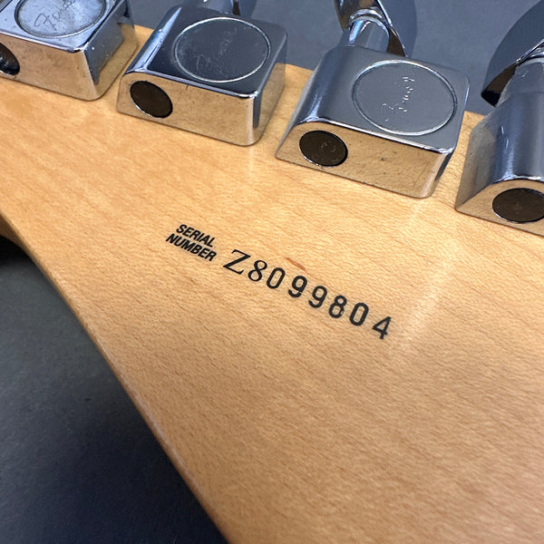 Close-up of Fender guitar serial number Z8099804 on the back of the maple neck near chrome tuning pegs