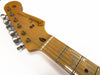 Close-up of vintage Fender Stratocaster electric guitar headstock with six tuning pegs and maple neck on white background
