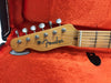 Close-up of Fender Telecaster guitar maple neck and headstock with vintage tuning pegs in orange plush-lined hard case