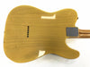 Back view of vintage yellow electric guitar body with string ferrules and metal neck plate on white background
