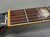 Close-up of guitar neck showing fretboard with metal frets, strings, and pearloid inlay on rosewood fingerboard from Coffee House Guitars