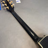 Back view of Gibson USA electric guitar neck and headstock with gold tuning pegs on gray background