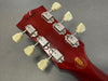 Back of red Gibson guitar headstock with vintage Kluson tuning pegs and Historic Collection decal, serial number 9100 6 visible.
