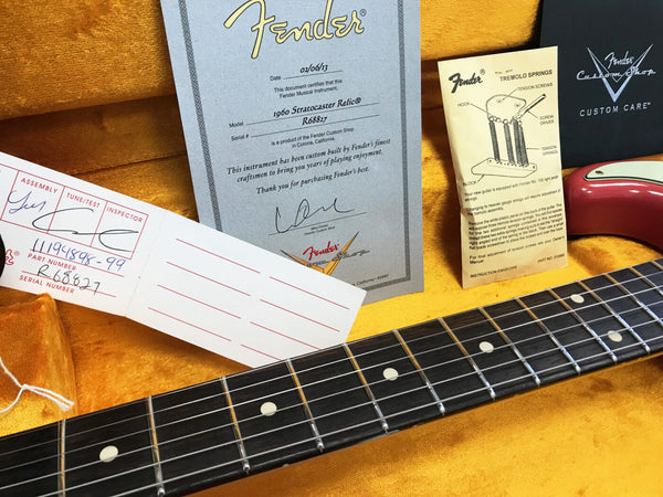 Fender Custom Shop 1960 Stratocaster Relic certificate of authenticity and instruction cards displayed inside yellow guitar case with Stratocaster guitar neck and rose red body edge visible