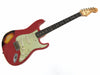 Vintage Fender Stratocaster electric guitar with red body, white pickguard, and rosewood fretboard showing heavy wear and relic finish