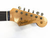 Close-up of Fender Stratocaster guitar headstock with tuning pegs and logo on natural wood finish