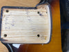 Close-up of a guitar neck pocket showing handwritten date and markings on the wood, highlighting the body finish in sunburst color.