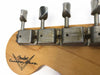 Close-up of vintage Fender Custom Shop guitar headstock showing aged tuning machines and logo on natural wood finish