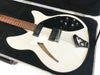 White semi-hollow electric guitar with black pickguard and dual humbucker pickups in hard case with black plush lining