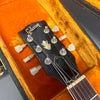 Close-up of Gibson guitar headstock with vintage tuners inside orange plush guitar case