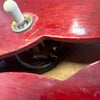 Close-up view of a red electric guitar body showing the pickup selector switch and internal wiring cavity.