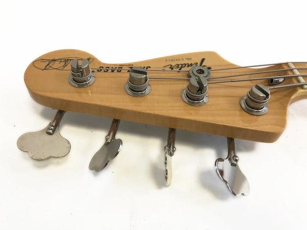 Close-up of Fender Jazz Bass guitar headstock with tuning pegs and strings on a white background