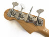Close-up of chrome bass guitar tuning pegs on natural wood headstock against white background