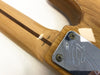 Close-up of guitar neck joint with "Crafted in Japan" text and chrome neck plate with engraved logo on natural wood finish electric guitar