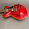 Red semi-hollow electric guitar with dual humbucker pickups, tortoiseshell pickguard, and four control knobs on gray background