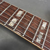 Close-up of rosewood guitar fretboard with rectangular pearloid inlays and metal frets on Coffee House Guitars electric guitar