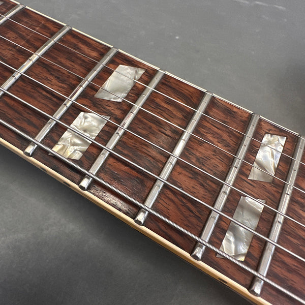 Close-up of rosewood guitar fretboard with rectangular pearloid inlays and metal frets on Coffee House Guitars electric guitar