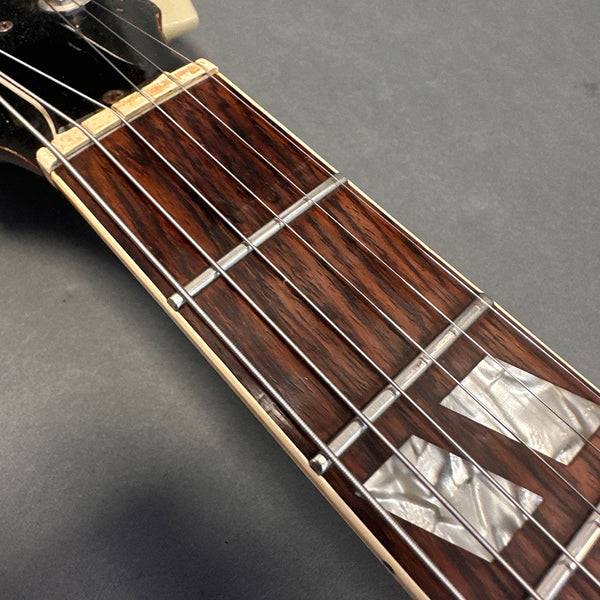 Close-up of rosewood guitar fretboard with mother of pearl block inlays and metal frets on Coffee House Guitars acoustic guitar