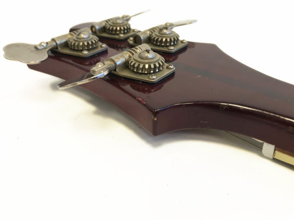 Close-up of vintage dark wood guitar headstock with metal tuning pegs and gears on white background