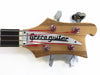 Greco bass guitar headstock with natural wood finish, black fretboard, chrome tuning pegs, and red-wrapped strings close-up on white background.