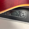 Close-up of acoustic guitar body edge on digital scale showing weight of 7.6 pounds