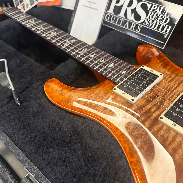 Close-up of Paul Reed Smith PRS electric guitar with flame maple top and bird inlays in a black plush guitar case at Coffee House Guitars.