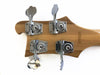 Close-up of bass guitar headstock with chrome tuning pegs and serial number D797221 on natural wood finish
