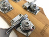 Close-up of guitar tuning pegs with Rickenbacker logo on natural wood headstock and serial number engraving