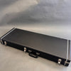 Black rectangular hard guitar case with silver clasps and handle on gray background