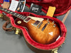 Gibson Les Paul electric guitar in sunburst finish inside red plush-lined brown hardshell case with Gibson owner's manual and accessories from Coffee House Guitars