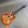 Electric guitar with flame maple top and bird inlays on fretboard on gray background