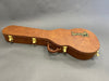 Brown Gibson guitar hard case with gold latches and leather handle on gray background