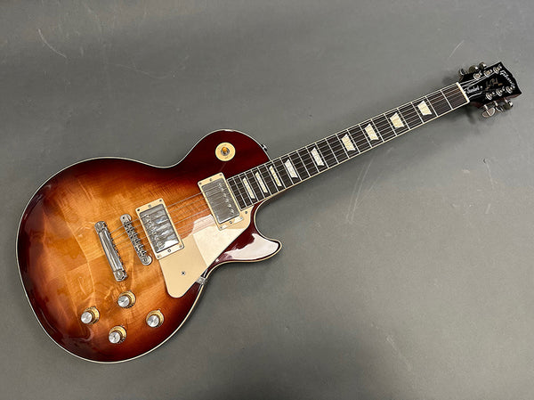 Electric guitar with sunburst finish, dual humbucker pickups, and chrome hardware, displayed on gray background at Coffee House Guitars.