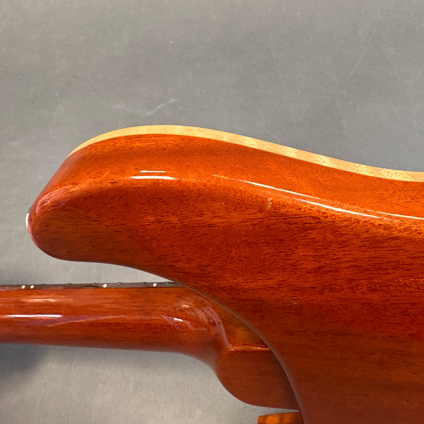 Close-up of glossy mahogany guitar body showing wood grain and smooth finish