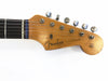 Close-up of vintage Fender Stratocaster guitar headstock with six tuning pegs and strings, showing original custom body decal and synchronized tremolo logo on natural wood finish.