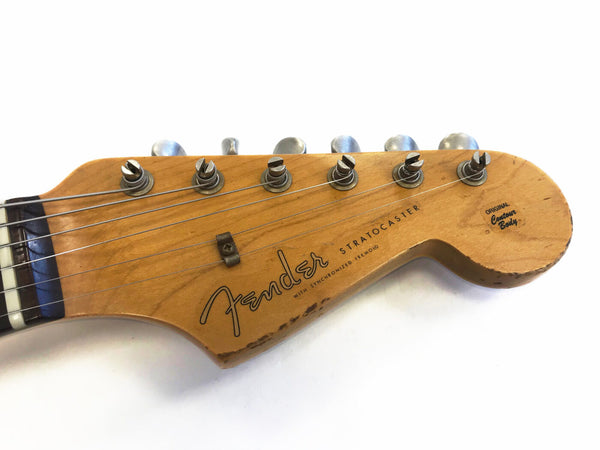 Close-up of vintage Fender Stratocaster guitar headstock with tuning pegs and original contour body logo on natural wood finish