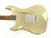 Back of cream vintage electric guitar body with visible wear and scratches, white plastic back plate, and metal neck plate on wooden neck