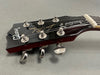 Close-up of Gibson Les Paul Standard electric guitar headstock with tuning pegs and strings, black finish, and logo clearly visible
