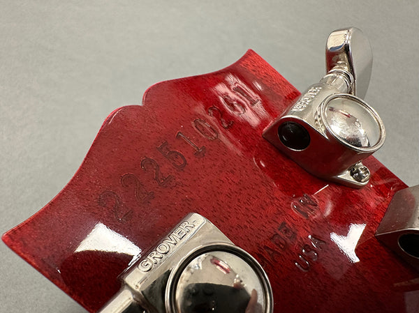 Close-up of red guitar headstock with serial number 222510261, Grover tuning pegs, and "Made in USA" engraving on the back.