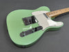 Seafoam green electric guitar with maple neck and chrome hardware on dark background