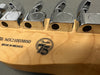 Close-up of Fender guitar headstock featuring chrome tuning pegs, serial number MX21003850, "Made in Mexico" stamp, and Fender 75th anniversary logo on maple wood.
