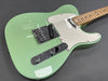 Electric guitar with seafoam green finish, white pickguard, chrome hardware, and maple neck on gray background