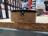 Close-up of guitar neck heel wood with visible screw and handwritten numbers on a workbench in a guitar workshop.