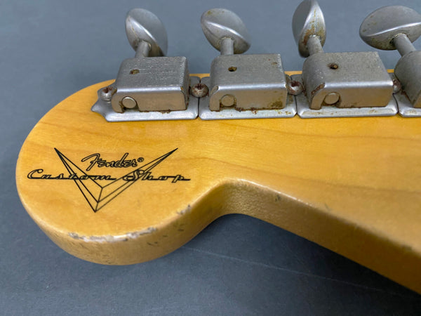 Close-up of Fender Custom Shop guitar headstock with vintage tuning machines and worn finish on maple wood neck