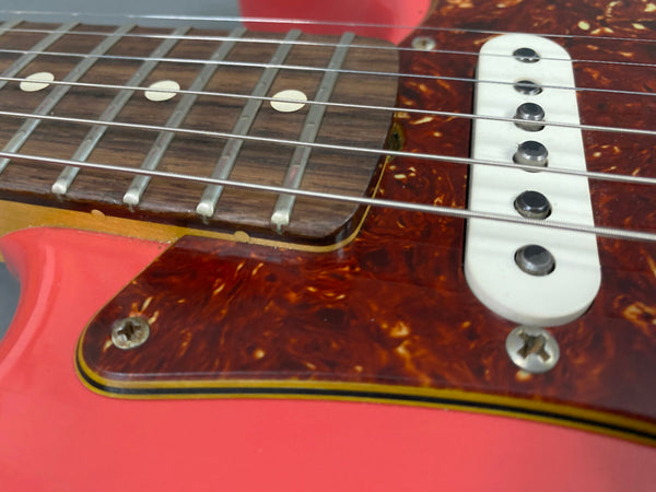 Close-up of coral pink electric guitar with rosewood fretboard, white single-coil pickup, and tortoiseshell pickguard at Coffee House Guitars.
